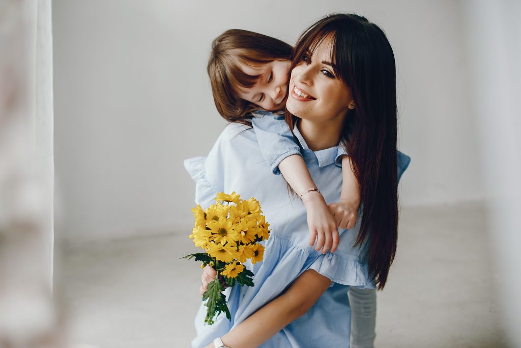Child give mother flowers. Family at home. Mothers day