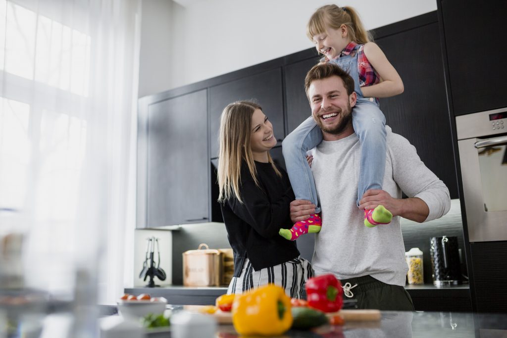 Family laughing together in the kitchen