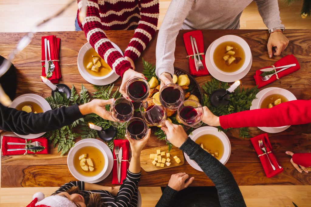 Being responsible with alcohol around foster children blog image - people sat around a christmas decorated table drinking red wine