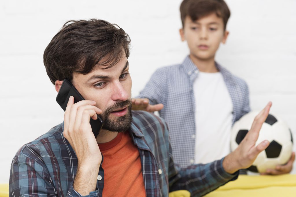 Son trying to get his dads attention whilst he is on the phone