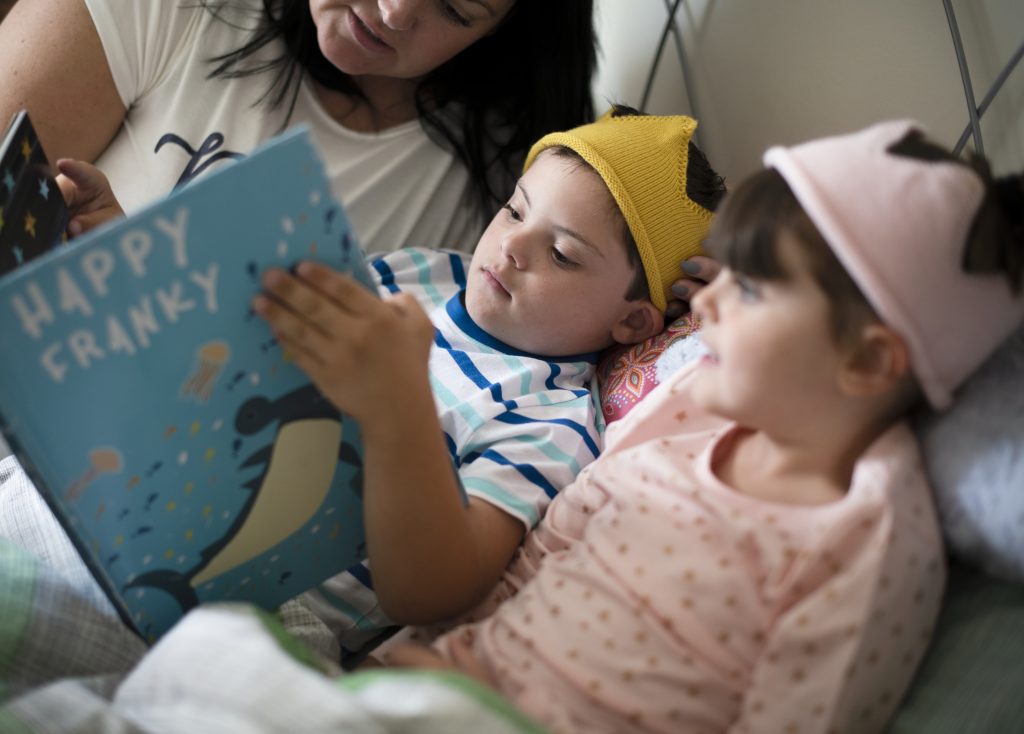 Mother reading a bedtime story to her foster children