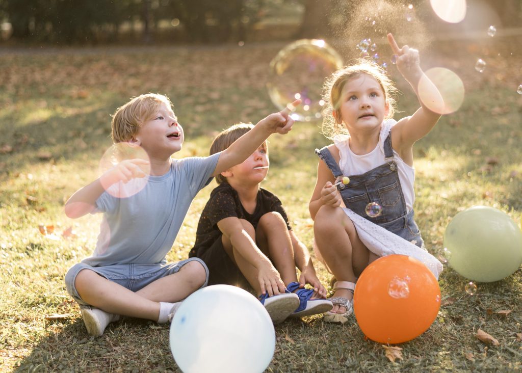 Three children in a park playing with some balloons - foster children with fostering agencies in Nottingham